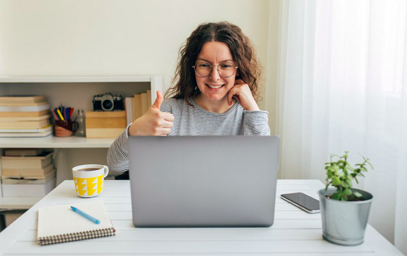 Thumbs up from a woman using a computer