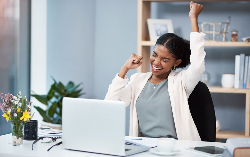 Woman using a laptop and happy