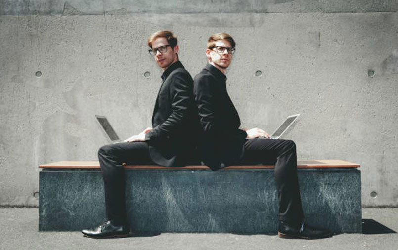 Twin brothers using laptops