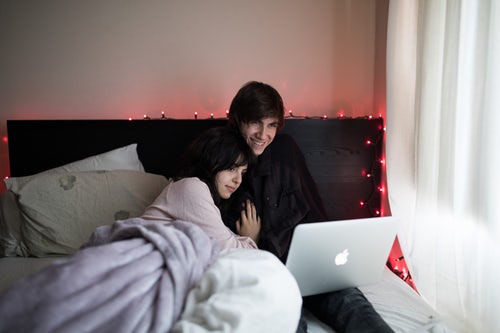 couple streaming tv in bed