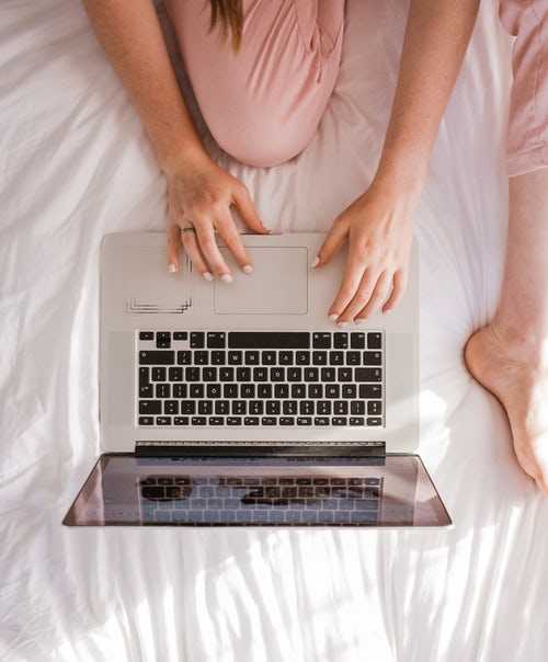woman in bed on computer