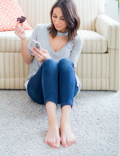 woman on floor eats and texts